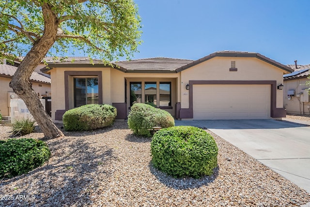 view of front of property with stucco siding, concrete driveway, a tiled roof, and a garage