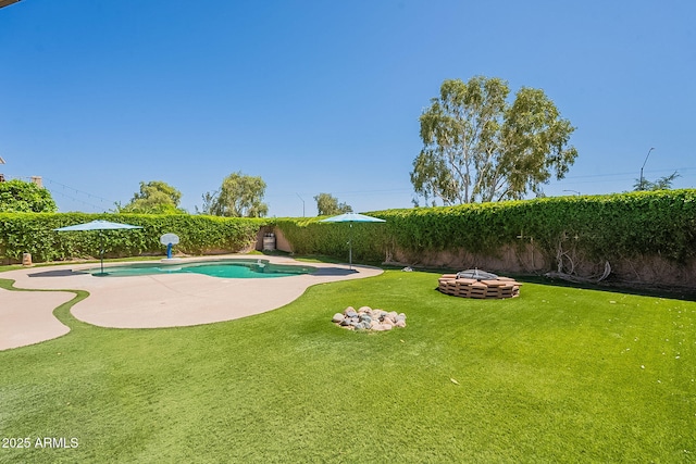 view of swimming pool with a fenced in pool, a lawn, a fenced backyard, and an outdoor fire pit