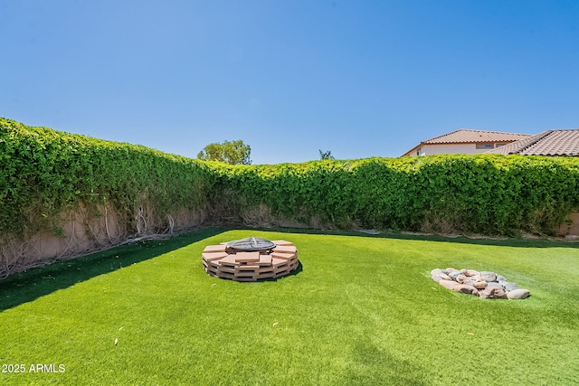 view of yard featuring a fire pit and a fenced backyard