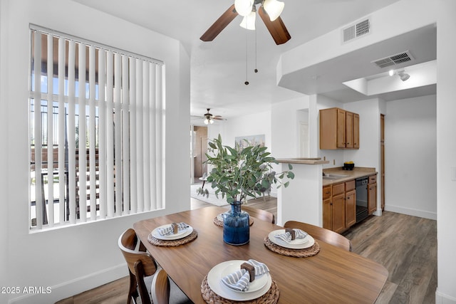 dining area featuring ceiling fan, baseboards, and light wood finished floors
