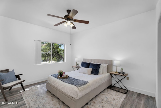 bedroom featuring wood finished floors, baseboards, and ceiling fan