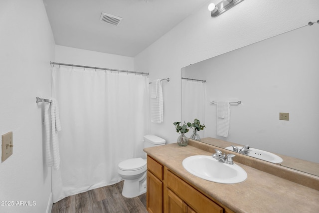 bathroom featuring wood finished floors, toilet, vanity, and curtained shower