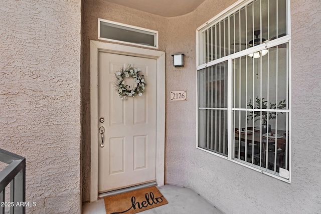 view of exterior entry with stucco siding