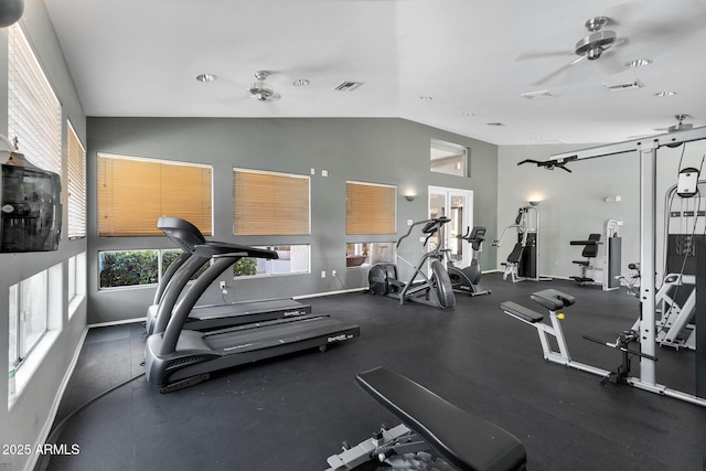gym with a ceiling fan, vaulted ceiling, and baseboards