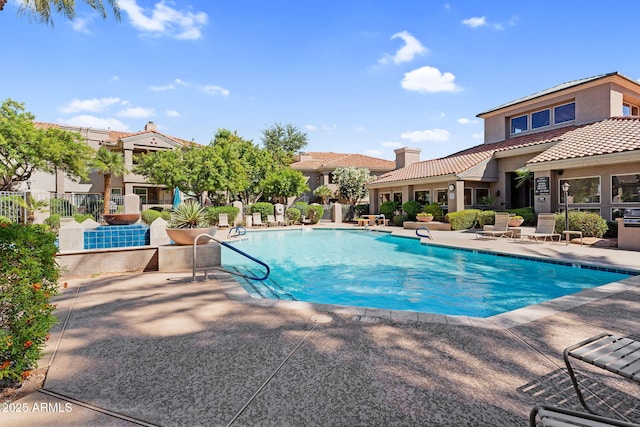 community pool with a patio and fence