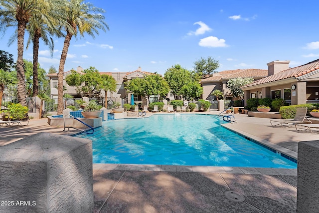 community pool featuring a patio and fence