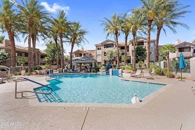 community pool featuring fence, a patio area, a gazebo, and a residential view