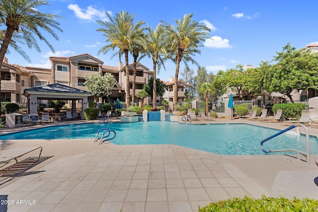 community pool with a gazebo, a patio, fence, and a residential view
