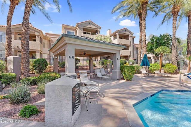 back of property with fence, stucco siding, a patio area, and a ceiling fan