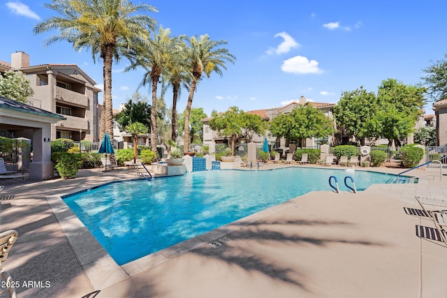 community pool with a patio area and a residential view