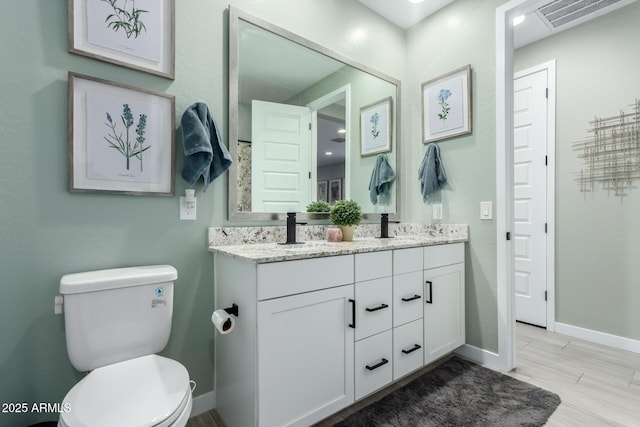 19414 W Highland Ave, Litchfield Park, AZ 85340 - full bathroom featuring double vanity, visible vents, a sink, baseboards, and toilet