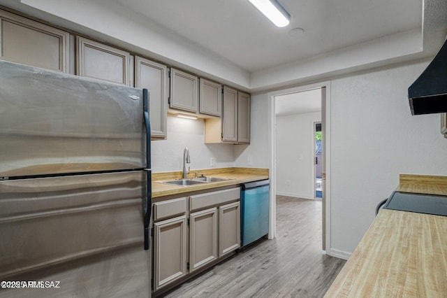 8118 N Gibraltar Dr, Tucson, AZ 85704 - kitchen featuring range hood, a sink, freestanding refrigerator, light wood-style floors, and dishwashing machine