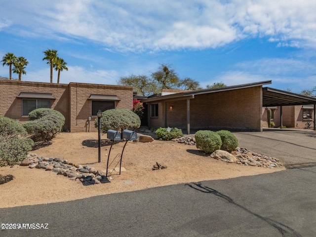 8118 N Gibraltar Dr, Tucson, AZ 85704 - mid-century home featuring aphalt driveway, an attached carport, and brick siding