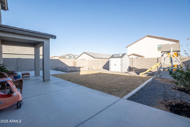 view of yard with a playground, a patio, and a shed