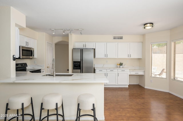 25825 N 65th Ave, Phoenix, AZ 85083 - kitchen with visible vents, a sink, a peninsula, a kitchen bar, and appliances with stainless steel finishes