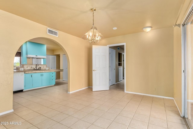 unfurnished dining area featuring visible vents, baseboards, light tile patterned flooring, arched walkways, and a sink