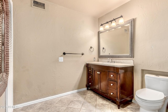 bathroom featuring visible vents, baseboards, toilet, tile patterned floors, and vanity