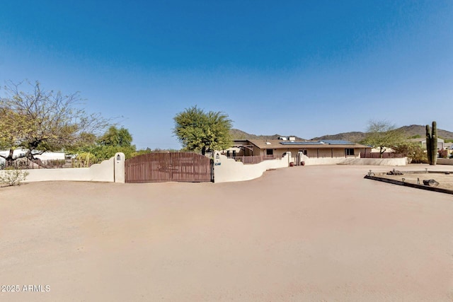 view of front of house with fence, solar panels, and a gate