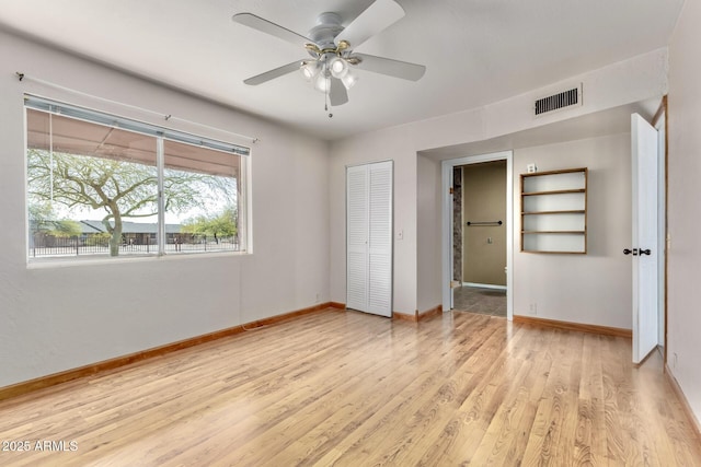 unfurnished bedroom featuring a ceiling fan, baseboards, visible vents, light wood-style flooring, and a closet