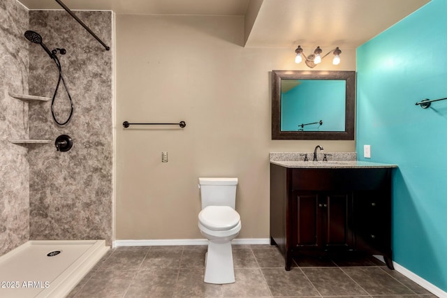 bathroom with baseboards, toilet, a tile shower, tile patterned floors, and vanity