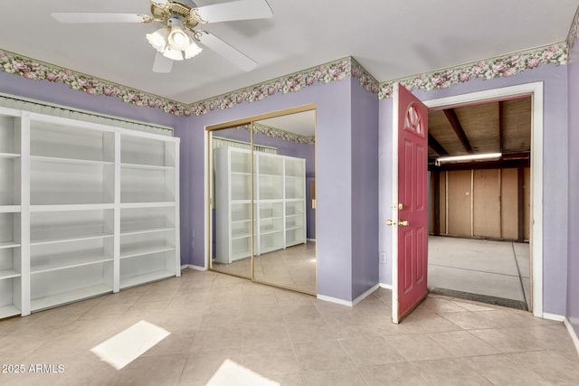 unfurnished bedroom featuring light tile patterned floors, a ceiling fan, and baseboards