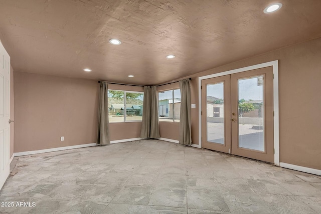 empty room featuring recessed lighting, french doors, and baseboards