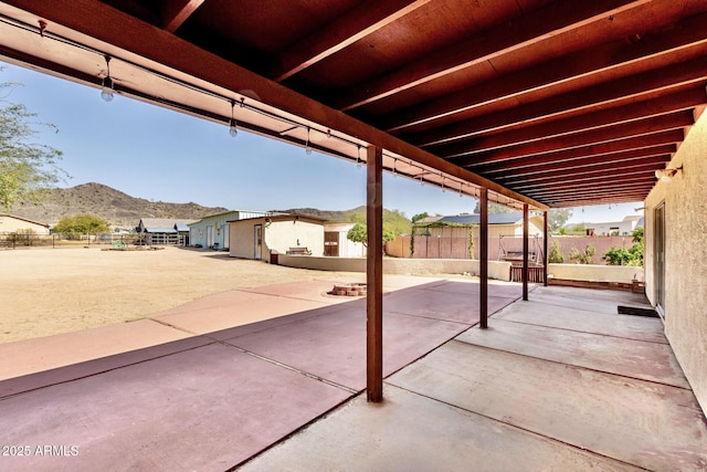 view of patio / terrace featuring a mountain view and fence