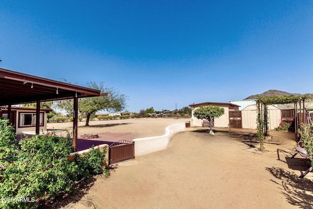 view of yard featuring an outbuilding, a storage shed, and fence