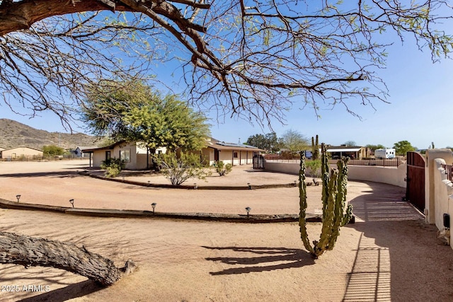 view of yard with a mountain view, fence, and a gate