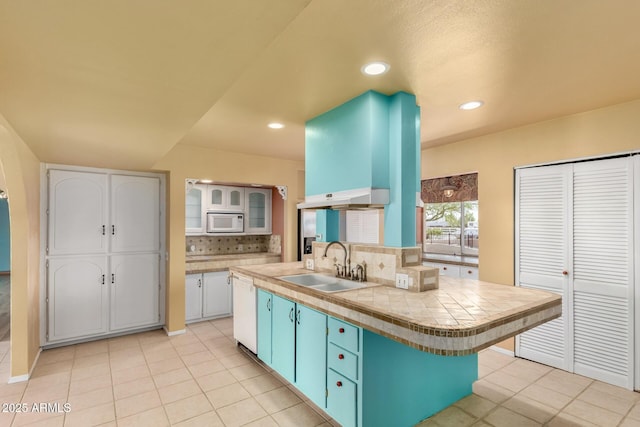 kitchen with tasteful backsplash, glass insert cabinets, white appliances, white cabinetry, and a sink