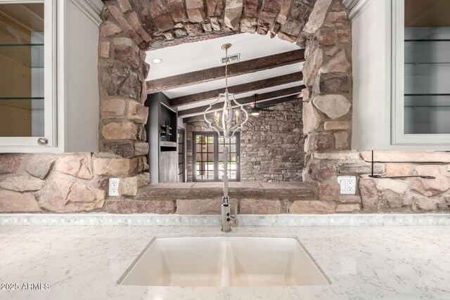3913 E Derringer Way, Gilbert, AZ 85297 - kitchen view of a sink, glass insert cabinets, light stone counters, and a chandelier