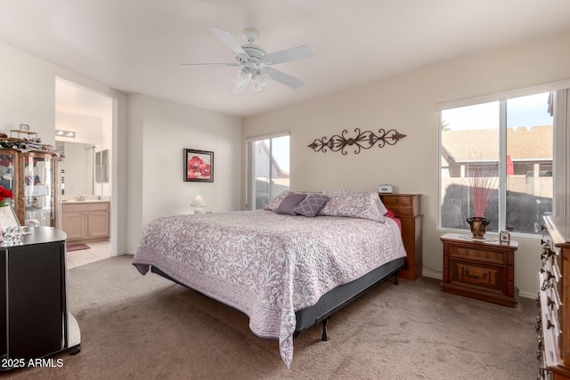 bedroom featuring multiple windows, sink, light carpet, and ceiling fan