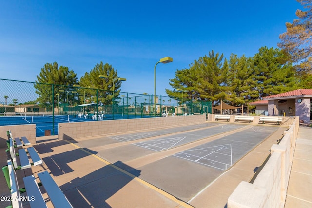 view of property's community featuring tennis court