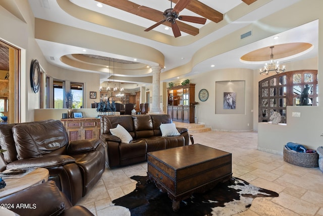 living room with ornate columns, a raised ceiling, and ceiling fan with notable chandelier