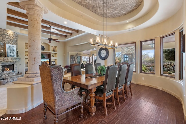 dining area featuring hardwood / wood-style floors, ceiling fan, a raised ceiling, and decorative columns