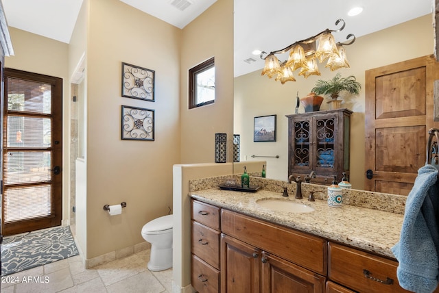 bathroom with a wealth of natural light, vanity, and toilet