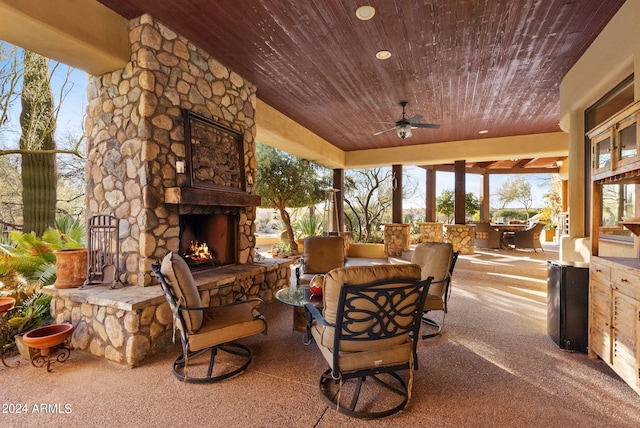 view of patio with ceiling fan and an outdoor stone fireplace