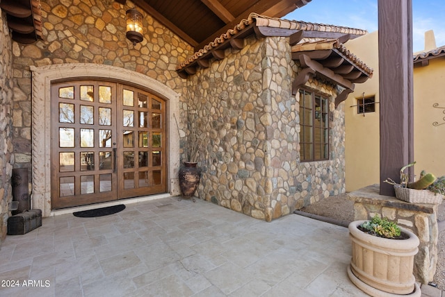 view of exterior entry featuring french doors and a patio