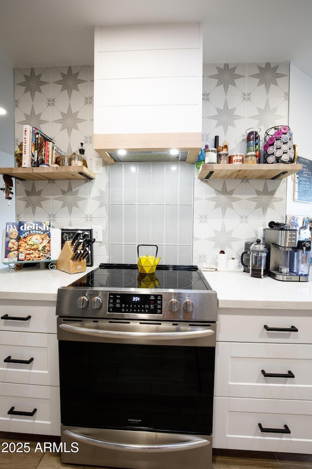 kitchen with open shelves, custom range hood, electric stove, and white cabinets