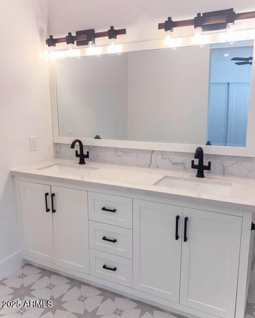 full bathroom with double vanity, baseboards, and a sink