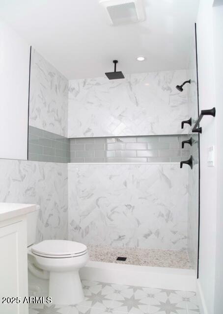 full bathroom with marble finish floor, toilet, walk in shower, and vanity