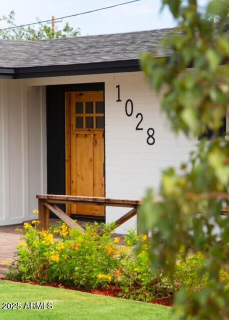 entrance to property with a shingled roof