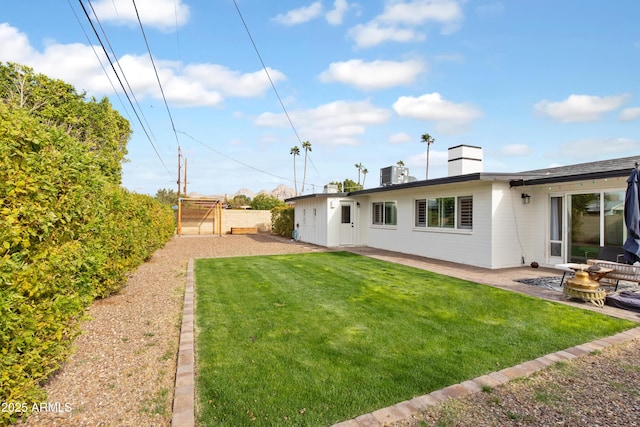 view of yard with fence, central AC, and a patio area