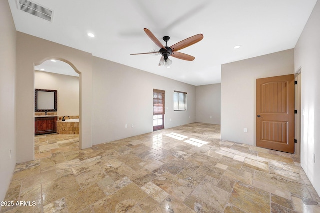 28758 N Ashbrook Ln, San Tan Valley, AZ 85144 - spare room with stone tile floors, a ceiling fan, arched walkways, and recessed lighting