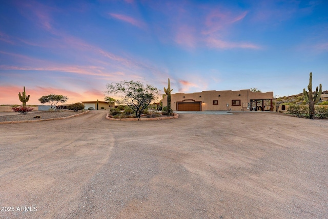28758 N Ashbrook Ln, San Tan Valley, AZ 85144 - pueblo-style home featuring an attached garage, stucco siding, and dirt driveway