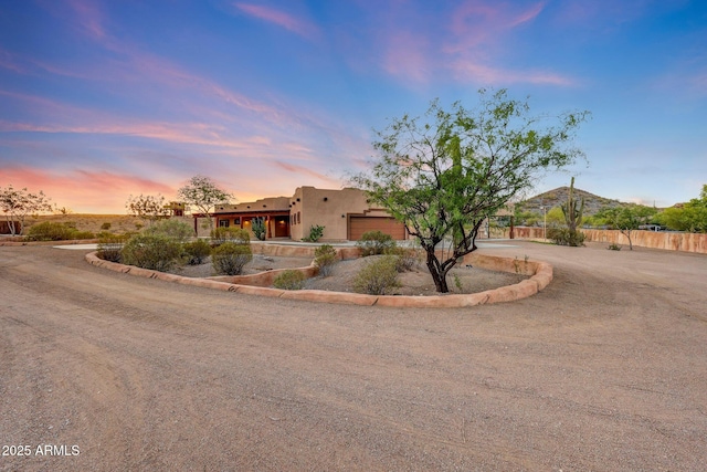 28758 N Ashbrook Ln, San Tan Valley, AZ 85144 - pueblo-style house with curved driveway, a garage, and stucco siding