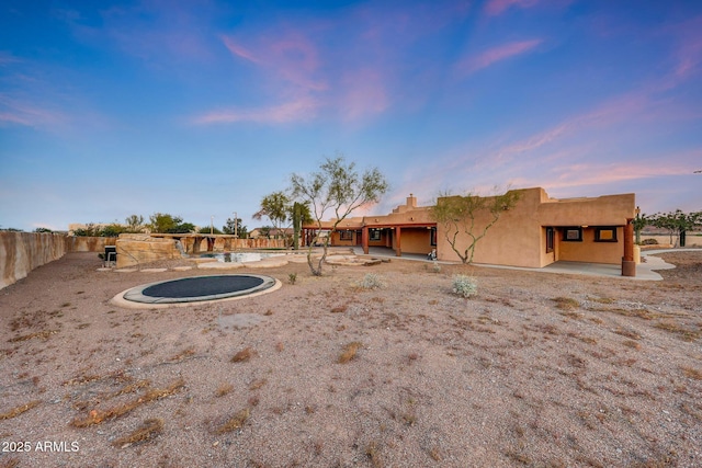 28758 N Ashbrook Ln, San Tan Valley, AZ 85144 - back of property at dusk featuring a patio, a pool, and stucco siding