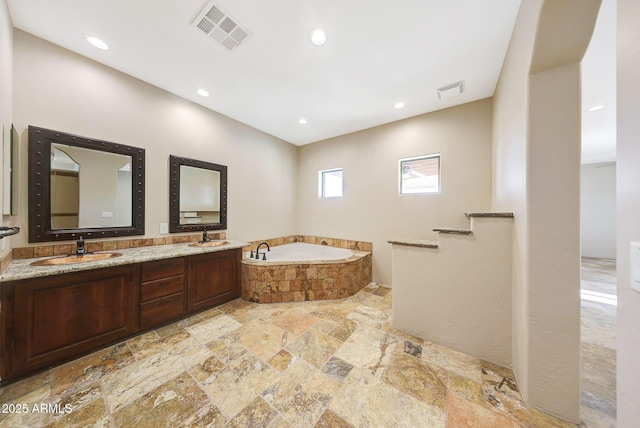 28758 N Ashbrook Ln, San Tan Valley, AZ 85144 - full bath with stone tile floors, a garden tub, double vanity, and recessed lighting