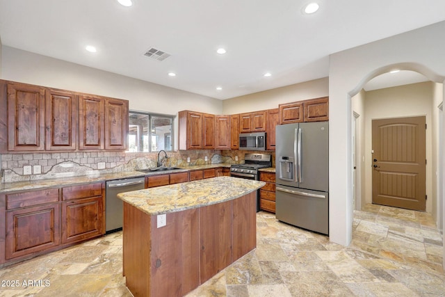 28758 N Ashbrook Ln, San Tan Valley, AZ 85144 - kitchen with stainless steel appliances, a sink, stone tile floors, light stone counters, and tasteful backsplash