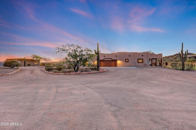 28758 N Ashbrook Ln, San Tan Valley, AZ 85144 - pueblo-style house featuring a garage, stucco siding, and dirt driveway